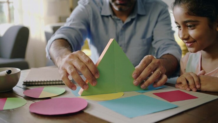 Lifting folded green triangle dad in blue shirt placing on yellow circle home table, teaching craft