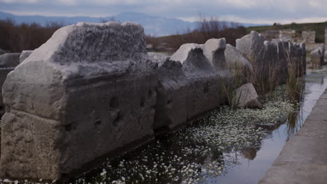 Cerca-De-Piedras-Antiguas-En-El-Agua-En-El-Gimnasio-Helenístico-De-Mileto.