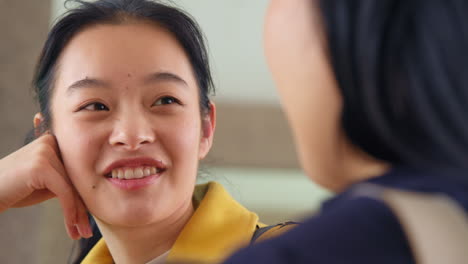 Close-Up-Of-Two-Smiling-Young-Female-Friends-Outside-Meeting-And-Talking-In-Urban-Setting