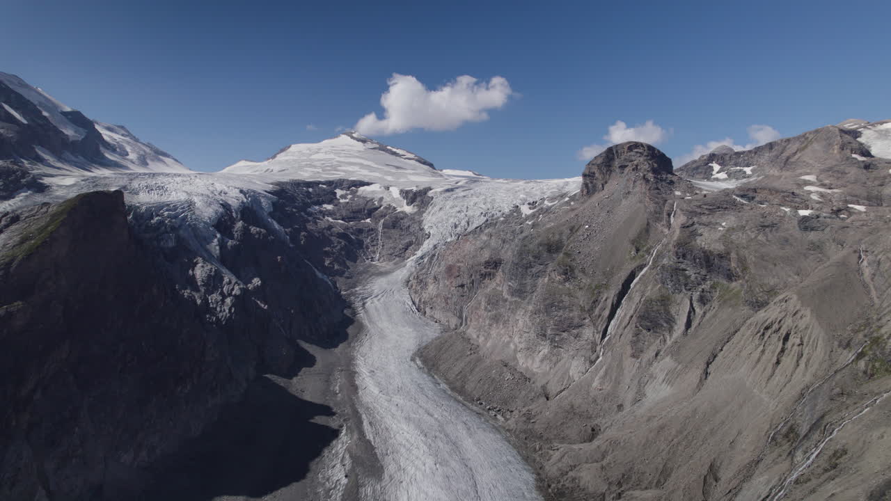 vista aérea panorámica del glaciar pasterze con el macizo grossglockner y el pico johannisberg, glaciar en retirada cubierto de morrena debido al calentamiento global