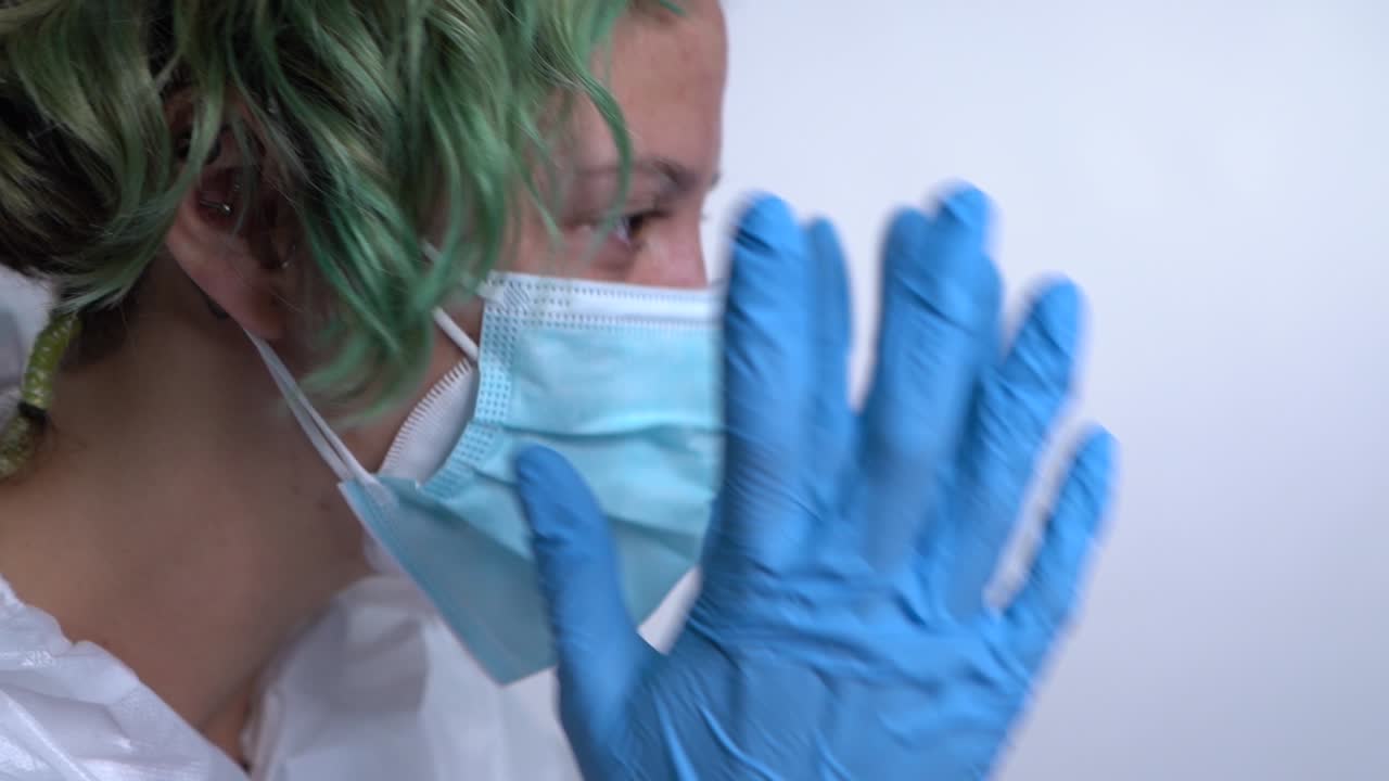 enfermera se lleva las manos a la cara desesperada por la situación del coronavirus