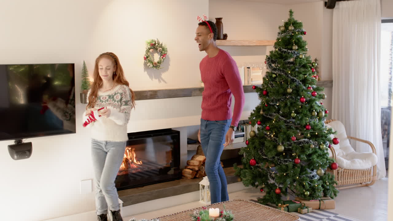 Couple decorating Christmas tree at home, enjoying festive holiday moments together