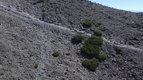 Aerial-shot-of-a-hiker-walking-along-a-trail-on-the-side-of-a-mountain-near-Lake-Tahoe-in-Northern-Nevada