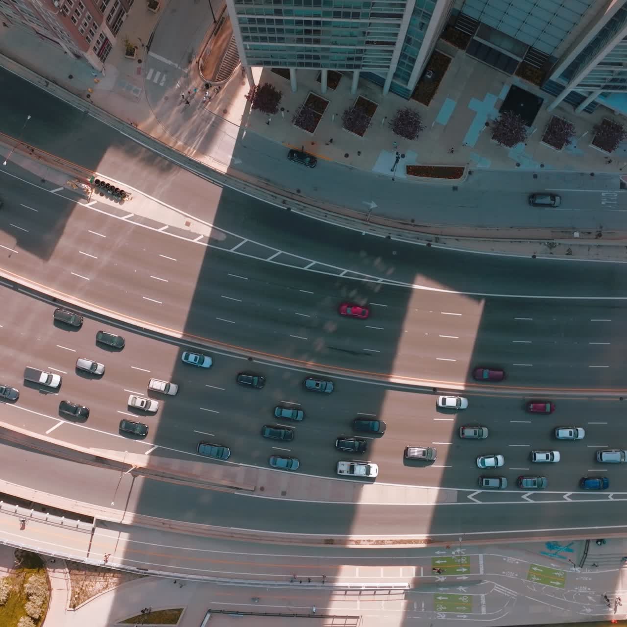 Quick and busy traffic on the wide-lane roads of Chicago. Birds' eye view on the highway between skyscrapers and green park