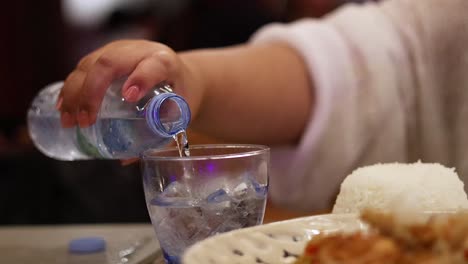 persona vertiendo agua en un vaso