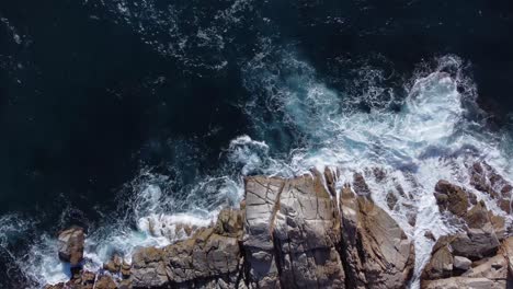 ondas espumosas do mar salpicando na costa rochosa à luz do sol