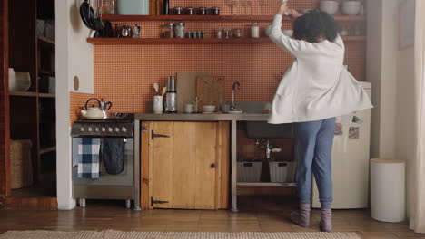 happy woman dancing in kitchen celebrating successful lifestyle enjoying cheerful victory dance celebration