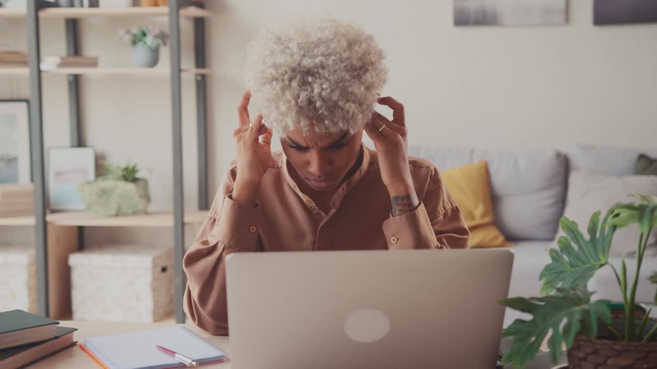 African woman at home tired feeling headache discomfort after long working day