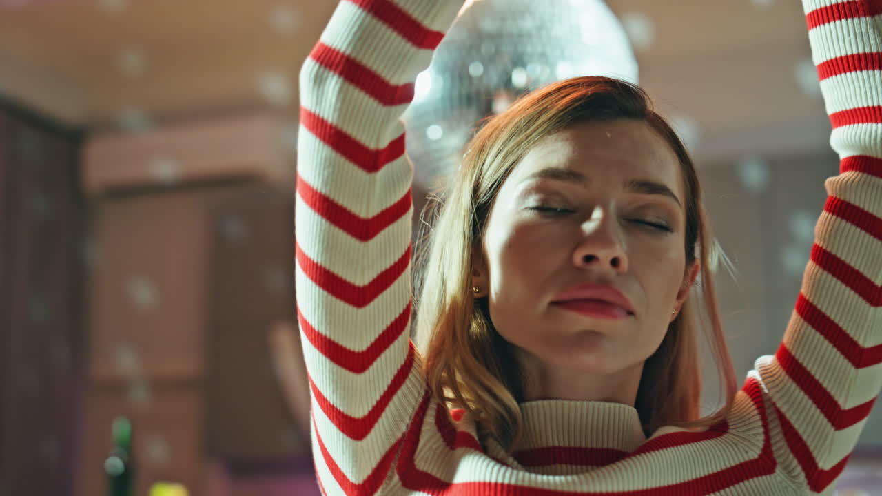 Drunk girl dancing alone in empty dark apartment close up. Woman holding beer