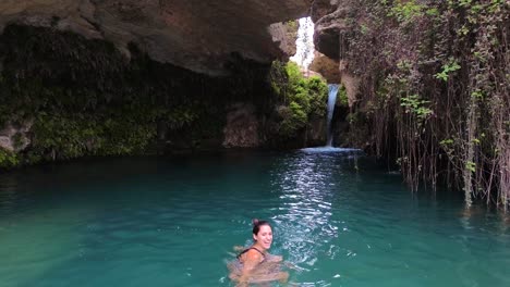 Beautiful-woman-take-bath-in-cavern-full-of-water-idyllic-landscape-called-"Salto-del-Usero"-in-Bullas,-Spain