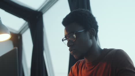 African Man Working on Laptop in Rooftop Office