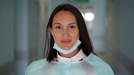 female doctor takes off her medical mask and surgeon cap and smiles