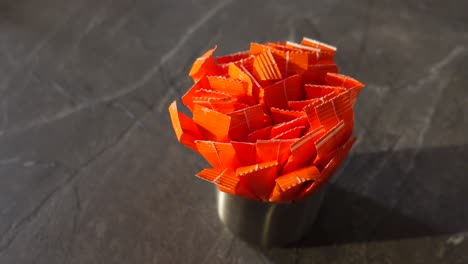 orange sugar packets in a metal container