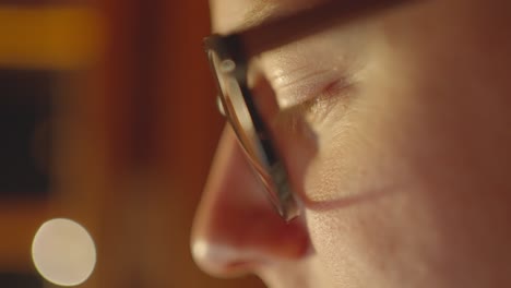 close up of caucasian male face squint eye and blink wearing glasses