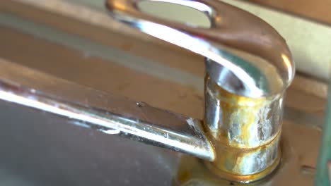 Caucasian-man-uses-old-rusty-tap-in-the-kitchen-sink