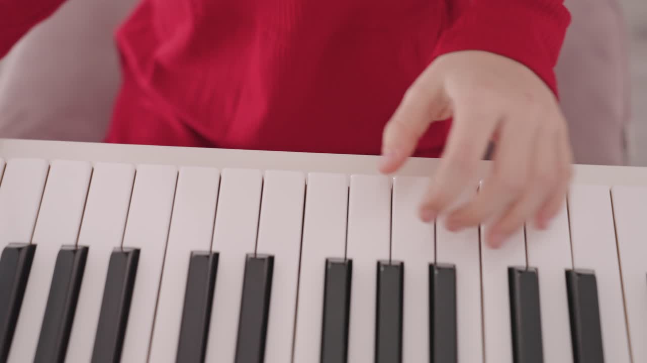 una niña talentosa con ropa roja toca el piano