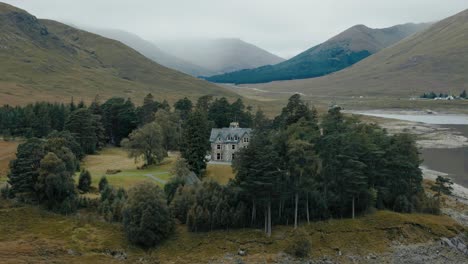 circle right view of loch cluanie and lone manor in the scottish highlands, scotland, with serene water and hills on overcast day