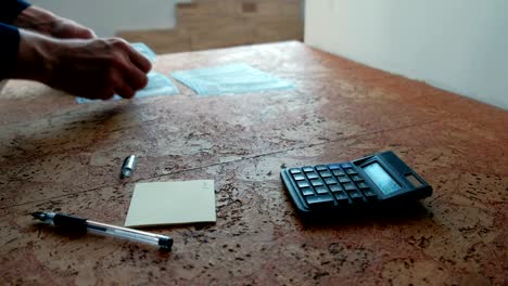 el hombre cuenta el dinero colocándolos en la mesa. manos de primer plano.