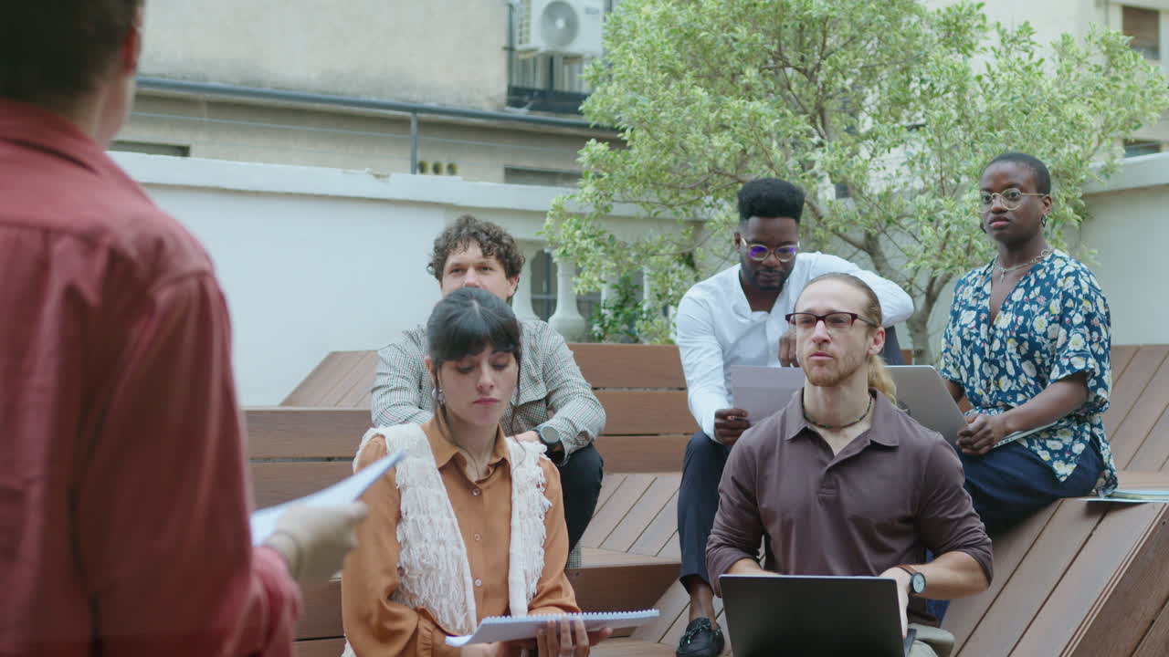 팀이 야외 비즈니스 회의에서 프로젝트 매니저를 듣고 있습니다.