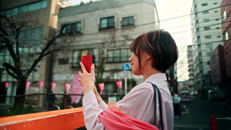 woman taking a photo in a city street