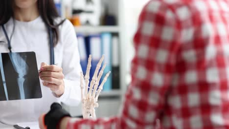 Doctor consulting with patient, showing hand X-ray