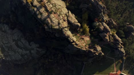 overhead drone shot moving from the bottom going up, revealing the length of the fortress and the natural rock formation