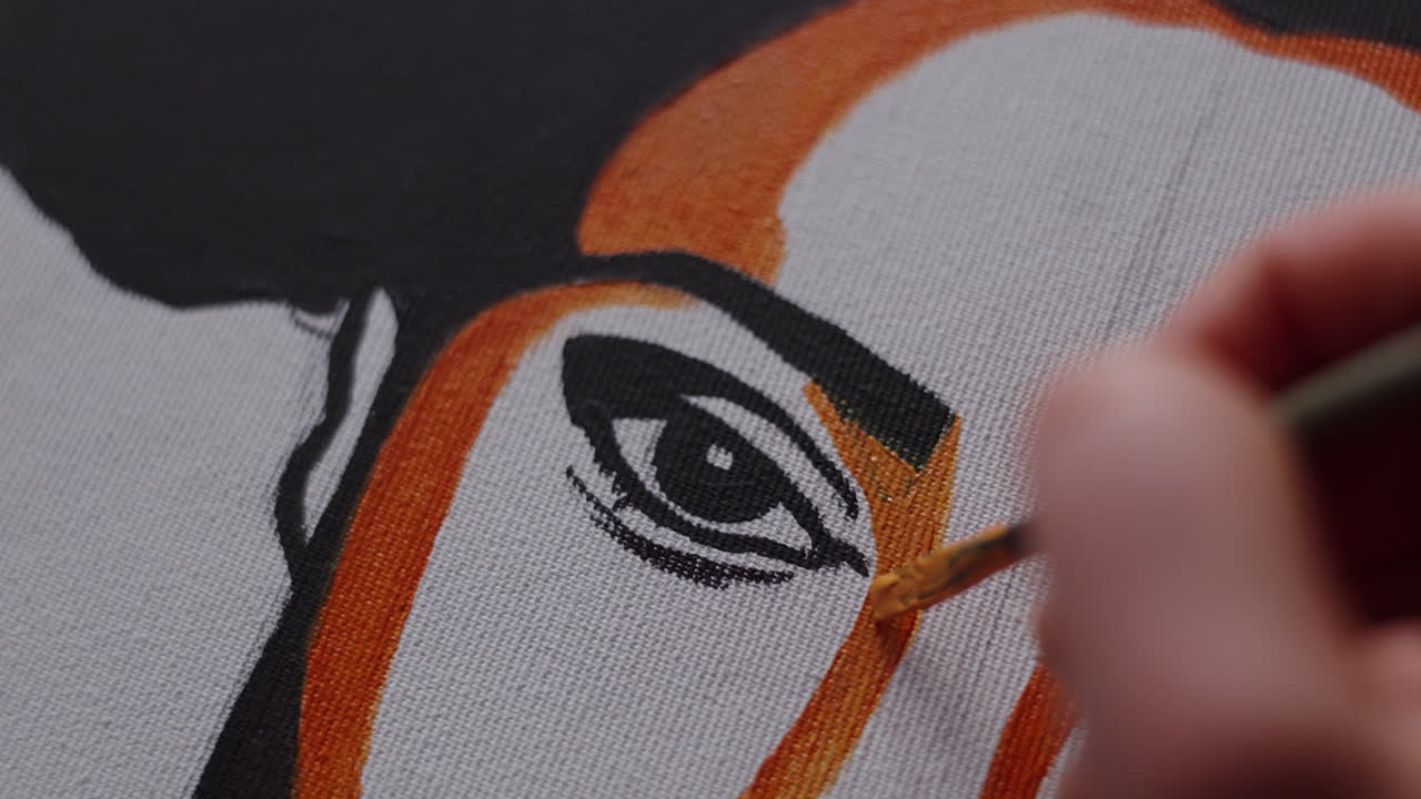Close-up of an artist painting a portrait of a person's eye.