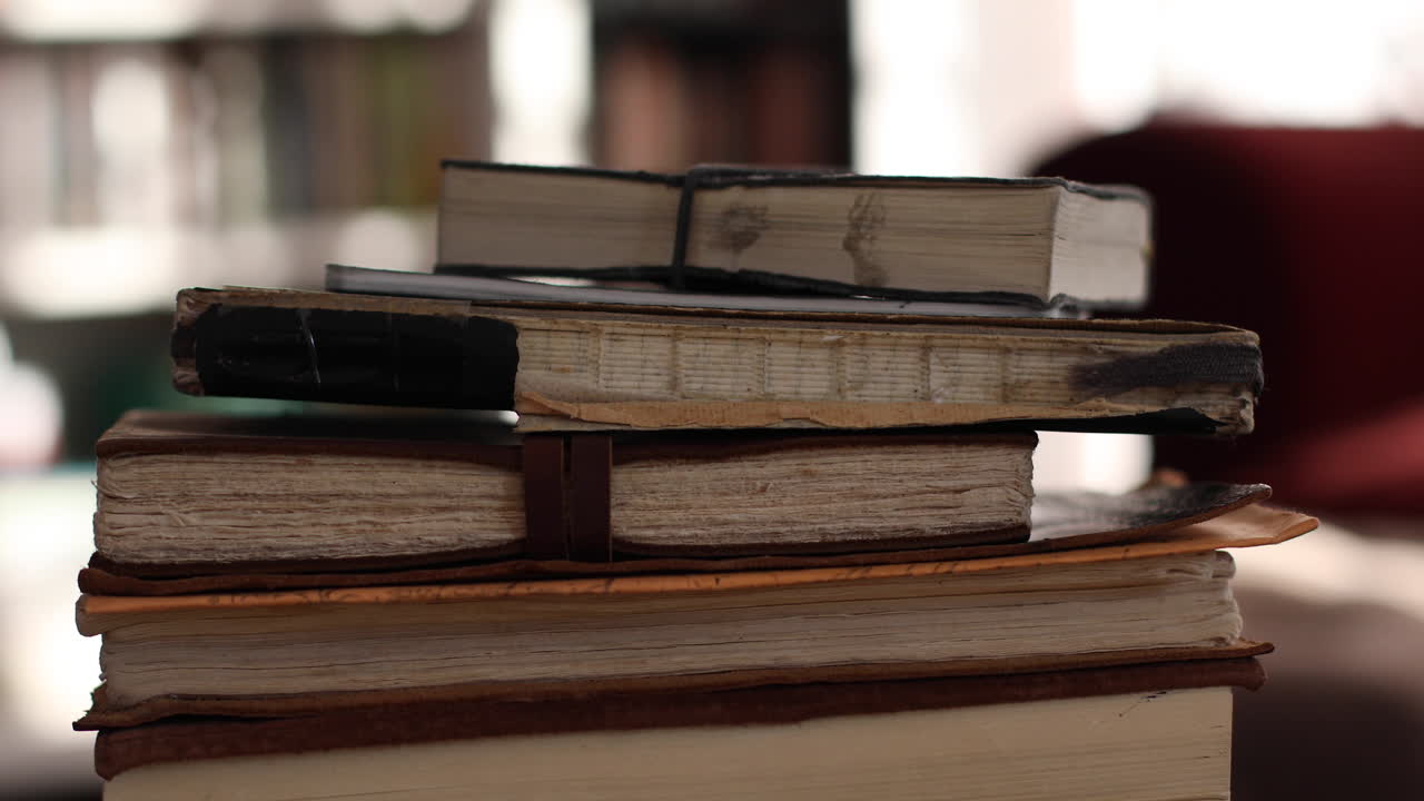 Shot moves from bottom pile of notebooks to the top of the pile