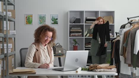 successful business, young female entrepreneur and her colleague celebrate online sales and give each other high five, retail