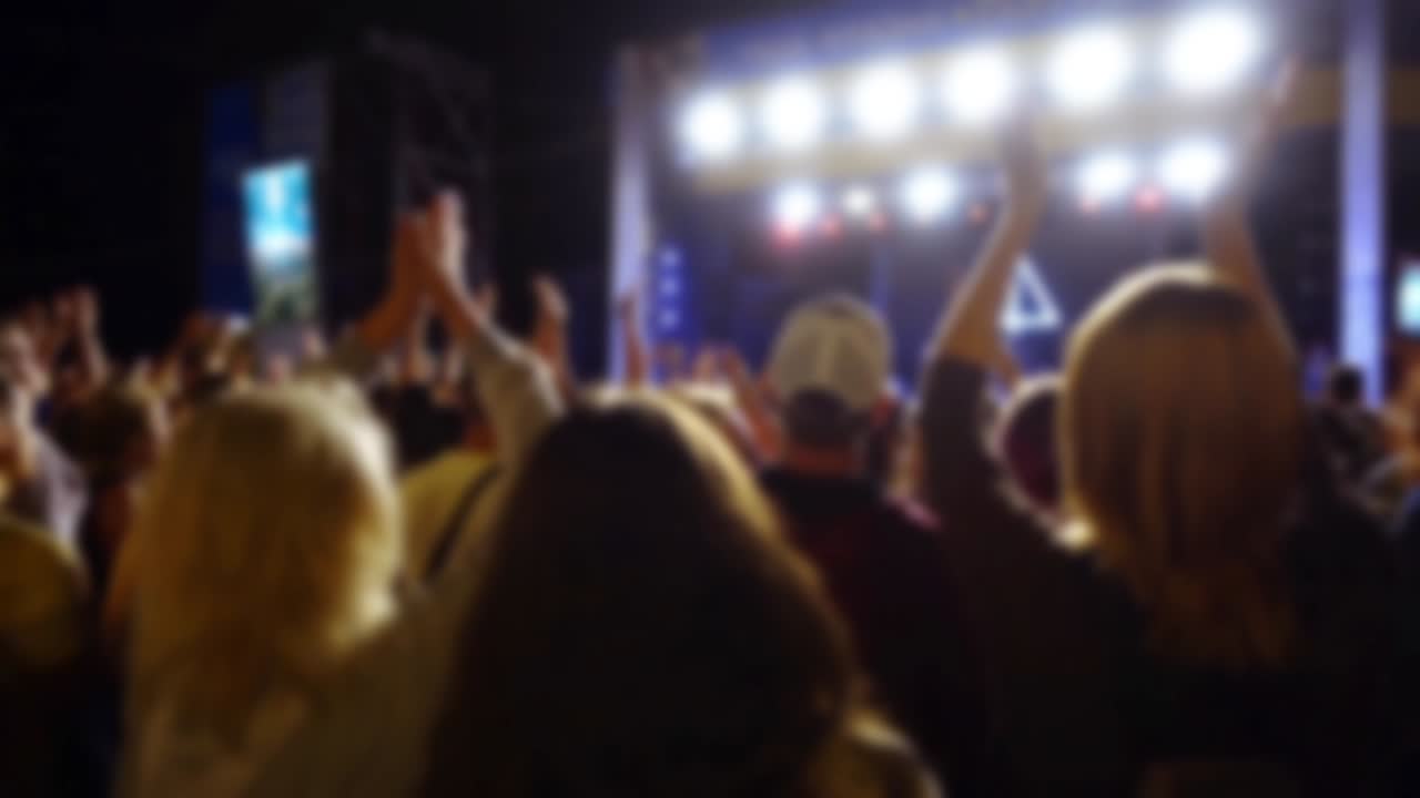 Concerto sul palco. Folla di persone e musicisti sulla scena. Fuori fuoco