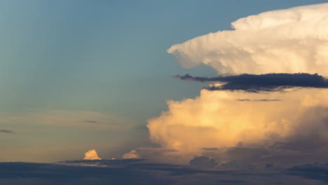 Cumulonimbus-cloud-after-the-storm,-spreading-orange-canopy-during-the-evening-setting-sun