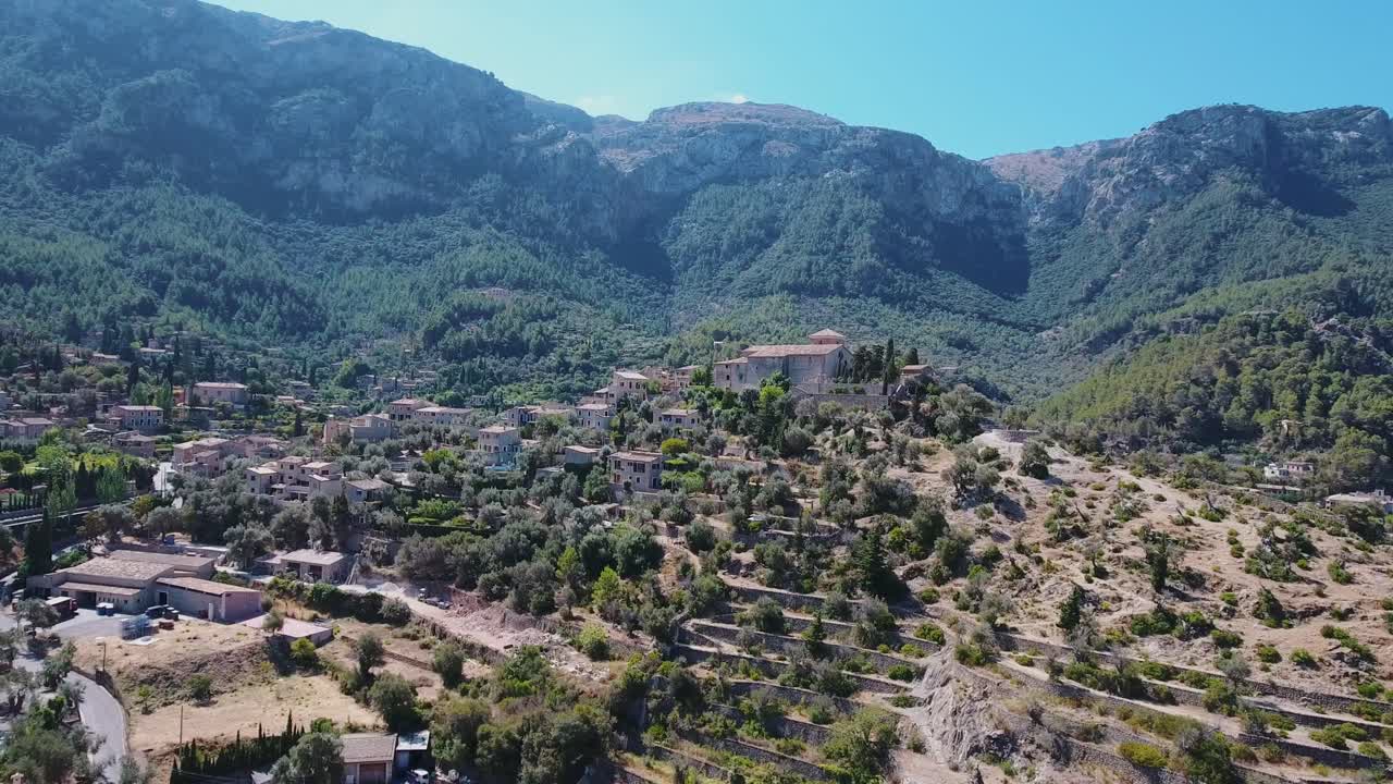 imágenes de drones de 4k de la parròquia sant joan baptista en deia, mallorca - impresionante paisaje en la costa oeste de mallorca con enormes acantilados en el fondo - pueblo español en las montañas - serra de tramuntana