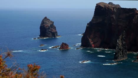 seascape timelapse of volcanic rock landforms in the sea with moving clouds and blue sky geology basalt magma beautiful breathtaking amazing red lava rocks scenary atlantic ocean waves sea formation