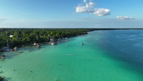 aerial view of coastline of the bacalar town, in sunny mexico - rising, drone shot