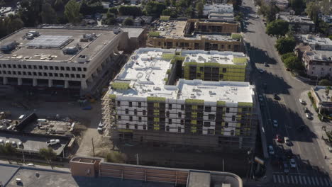 4K-aerial-shot-of-new-construction-of-a-large-apartment-building-in-Sherman-Oaks-California-with-the-101-freeway-in-the-background