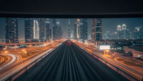 night view of a modern city skyline from an elevated metro track