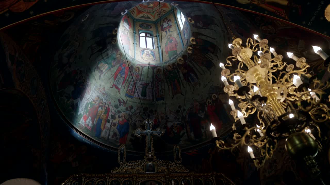 Lampadario e affreschi a cupola di chiesa ortodossa. - angolazione dal basso