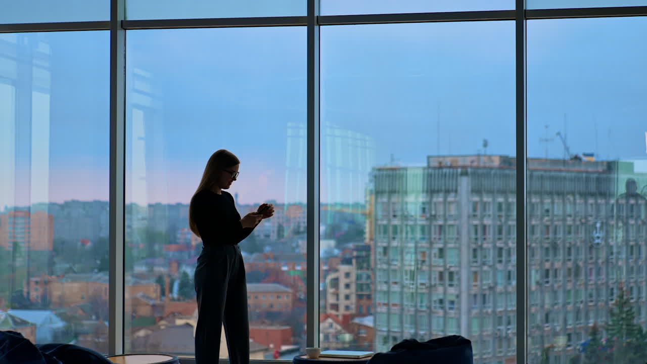 A beautiful smiling woman wearing eyeglasses is using a phone