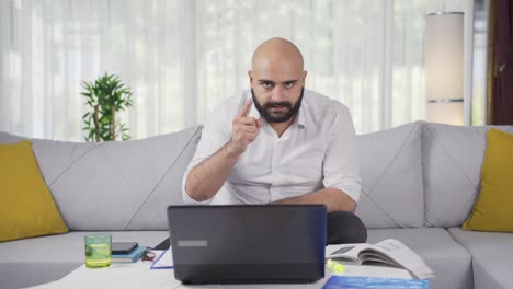 Ein-Mann,-Der-Im-Home-Office-Arbeitet,-Blickt-Mit-Einer-Ernsten,-Wütenden-Warnung-In-Die-Kamera.