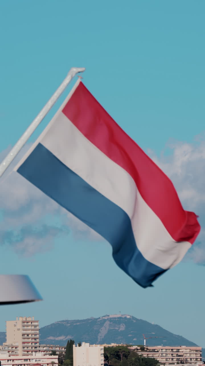 The flag of Netherlands waving on a boat docked in the Port Camille Rayon in Antibes, France. Vertical