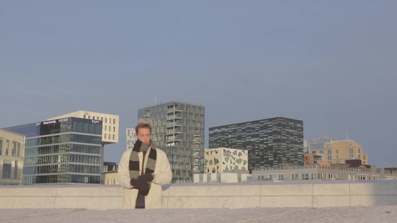 Giovane uomo che guarda lo skyline Barcode dal tetto dell'Opera di Oslo