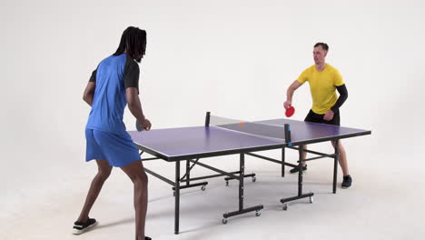 multiracial male table tennis players serving and passing the ball to each other on white background
