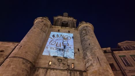 close-up view of the clock tower or tour de l'horloge at night during the francofolies festival, la rochelle, france.