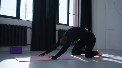 woman doing yoga stretches in a studio