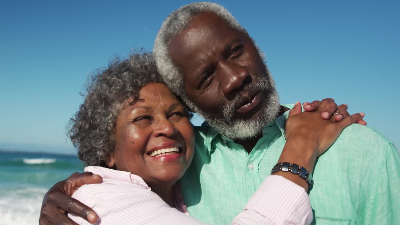 Senior couple looking at the camera at the beach