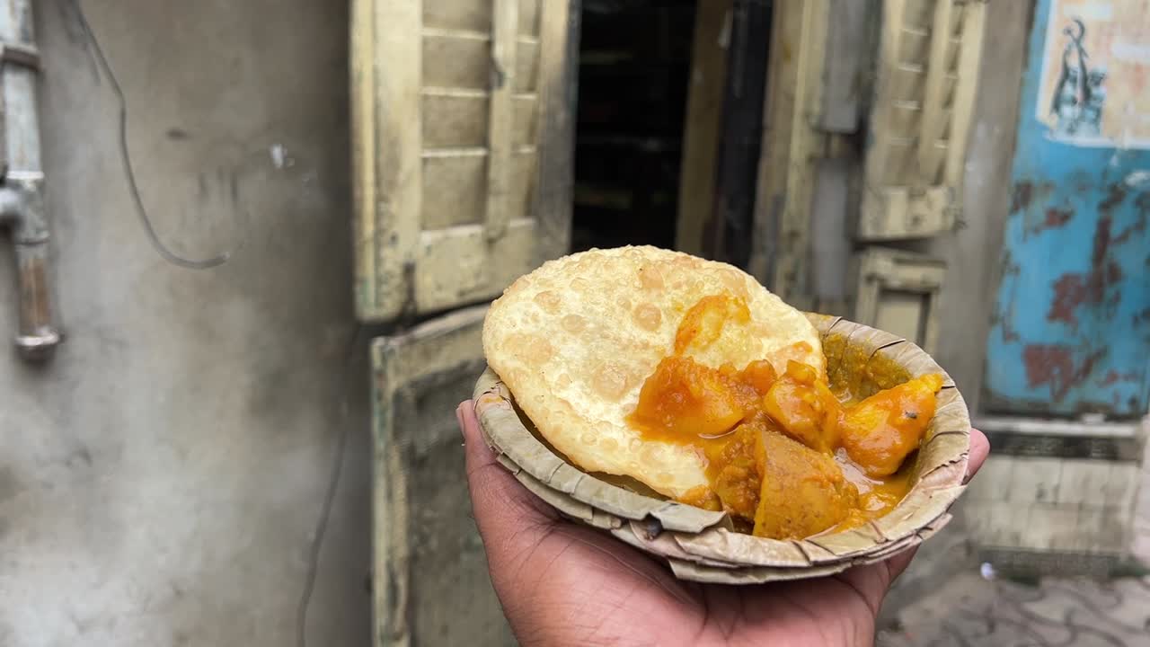 Radhaballabhi e alu dum davanti a un antico portale storico nel Bengala, India.