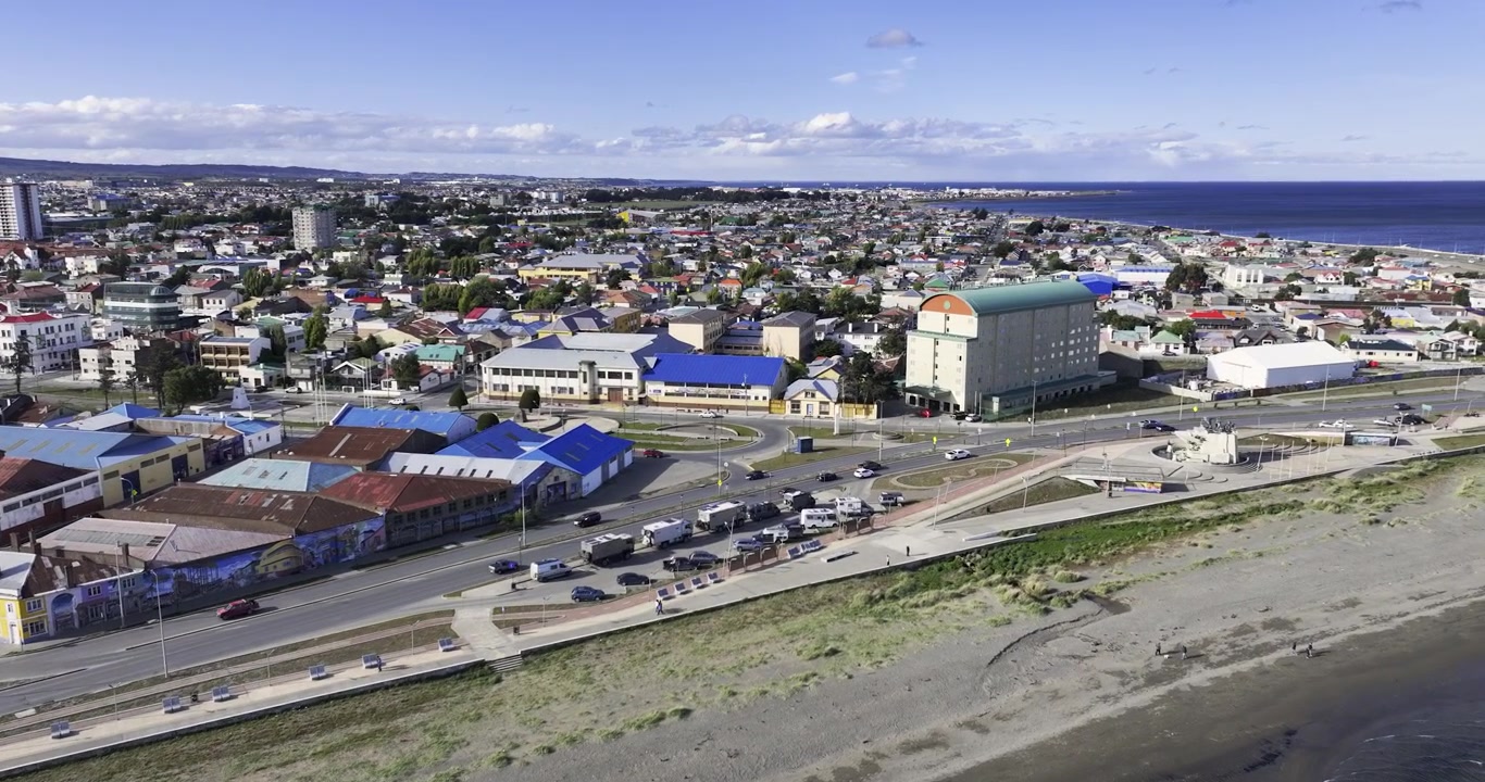 Dronekuva Punta Arenasista, Patagoniasta, Chilestä. Rantatien liikennettä ja rakennuksia aurinkoisena päivänä