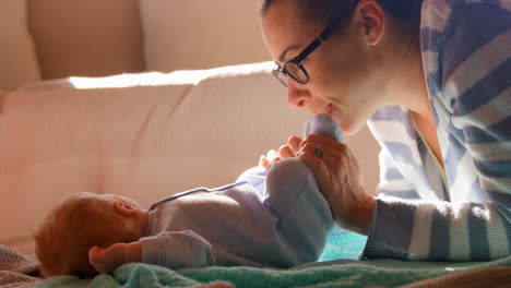 Mother-playing-with-her-baby-boy-feet-in-living-room-4k