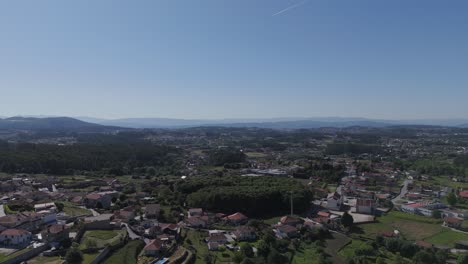 sunny wide aerial shot of Paços de Ferreira with trees hills and rooftops