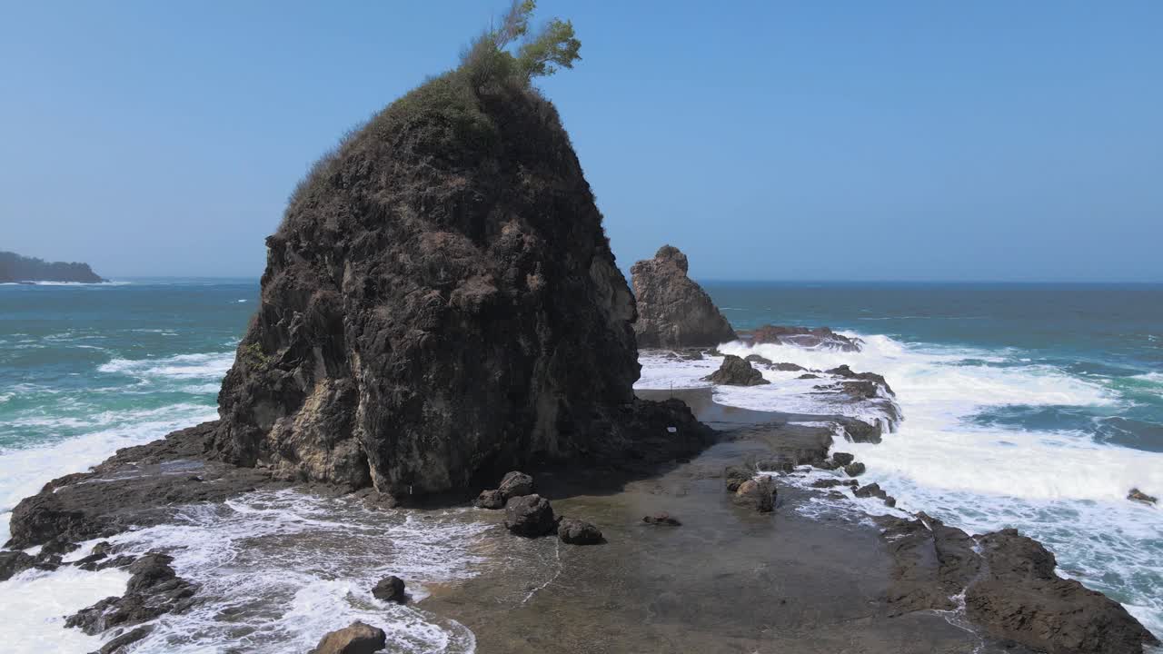 vista aérea de una isla de coral en el mar golpeada por olas de marea con cielo azul en el fondo